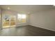 Sun-filled living room showcasing hardwood floors, large window, and sliding glass door to the deck at 2323 Hunter Woods Dr # 566, Apex, NC 27502