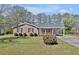 Traditional home boasts well-kept lawn, mature trees, and a brick facade with dark shutters at 2624 Gary Rd, Rocky Mount, NC 27803