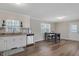 Open-concept kitchen and dining area with modern laminate floors and abundant natural light from two windows at 2624 Gary Rd, Rocky Mount, NC 27803