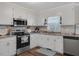 Bright kitchen features white cabinetry, stainless steel appliances, and an abundance of natural light at 2624 Gary Rd, Rocky Mount, NC 27803