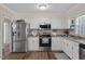 Bright kitchen features stainless steel appliances, crisp white cabinetry, and wood-look flooring at 2624 Gary Rd, Rocky Mount, NC 27803