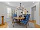 Cozy dining area featuring a round table, chandelier, and plenty of natural light from the windows at 2701 Glenwood Gardens Ln, Raleigh, NC 27608