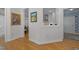 Inviting hallway with beautiful hardwood floors and decorative artwork; showcasing an entrance to the home's kitchen at 2701 Glenwood Gardens Ln, Raleigh, NC 27608