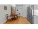 Bright breakfast nook with hardwood floors, a round table, and stainless steel refrigerator; an inviting eat-in space at 2701 Glenwood Gardens Ln, Raleigh, NC 27608
