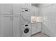 Efficient laundry room with white cabinetry, stacked washer and dryer, and convenient countertop space; modern design at 2701 Glenwood Gardens Ln, Raleigh, NC 27608
