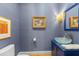 Stylish powder room with blue walls, glass bowl sink, and decorative lighting at 2701 Glenwood Gardens Ln, Raleigh, NC 27608