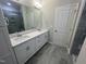 Bathroom featuring dual-sink vanity with white cabinets and gray ceramic tile flooring at 2723 Hunter Woods Dr # 566, Apex, NC 27502