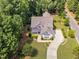 An aerial view of a landscaped property, highlighting the home, driveway, and surrounding greenery at 277 High Ridge Ln, Pittsboro, NC 27312