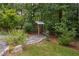 Landscaped backyard with a decorative birdhouse and lush surrounding greenery at 277 High Ridge Ln, Pittsboro, NC 27312