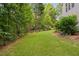 Well-maintained backyard with lush green grass, mature trees, and landscaping along the treeline at 277 High Ridge Ln, Pittsboro, NC 27312