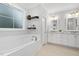 Bright bathroom with a soaking tub, tile surround, window, and dual vanity sinks with marble countertops at 277 High Ridge Ln, Pittsboro, NC 27312