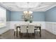 Dining room featuring wainscoting, a coffered ceiling, hardwood floors, and a modern chandelier over the dining table at 277 High Ridge Ln, Pittsboro, NC 27312