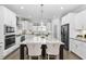 Bright kitchen featuring a black refrigerator, white cabinets, granite counters, and large island with seating at 277 High Ridge Ln, Pittsboro, NC 27312