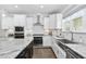 Kitchen showcasing granite countertops, stainless steel appliances, white cabinetry, and an island with barstool seating at 277 High Ridge Ln, Pittsboro, NC 27312
