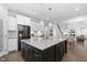 Large kitchen island featuring granite countertops, seating, and view of dining and living spaces at 277 High Ridge Ln, Pittsboro, NC 27312