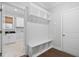 Mudroom boasts built-in bench with storage, hooks, a white door, and an entrance to the laundry room at 277 High Ridge Ln, Pittsboro, NC 27312