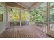 Screened-in porch has wood floors, and a view of the backyard full of trees and greenery at 277 High Ridge Ln, Pittsboro, NC 27312