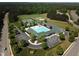 Aerial view of community pool, tennis courts, and soccer field surrounded by lush greenery and trees at 277 High Ridge Ln, Pittsboro, NC 27312