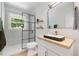 Modern bathroom with sleek fixtures, a walk-in shower, and natural light from a window at 2904 Sprucewood Dr, Durham, NC 27707
