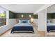 Bright bedroom featuring a blue bed set, hardwood floors, and green accent wall at 2904 Sprucewood Dr, Durham, NC 27707