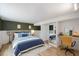 Bright bedroom featuring a blue bed set, hardwood floors, and desk at 2904 Sprucewood Dr, Durham, NC 27707
