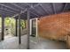 A close-up view of the covered patio, showing brick wall, concrete floor, and support beams at 2904 Sprucewood Dr, Durham, NC 27707