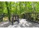 View of deck with gray wood and railing surrounded by green trees at 2904 Sprucewood Dr, Durham, NC 27707