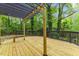 Expansive deck with custom pergola and bench seating, great outdoor living space with picturesque wooded views at 2904 Sprucewood Dr, Durham, NC 27707