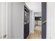 Hallway showcasing hardwood floors, white walls, and a black front door with glass panes at 2904 Sprucewood Dr, Durham, NC 27707