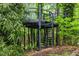 Elevated treehouse with spiral staircase surrounded by trees, blending seamlessly with its natural setting at 2904 Sprucewood Dr, Durham, NC 27707