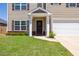 Charming front exterior with a well-manicured lawn, garden bed, and welcoming front door at 2923 Cullens Dr, Graham, NC 27253