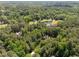 Aerial view of a home surrounded by mature trees, a lake and greenery at 3203 Rugby Rd, Durham, NC 27707