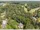 Aerial view of a home among mature trees with a golf course visible at 3203 Rugby Rd, Durham, NC 27707