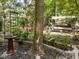 Lush backyard featuring a bird bath, swing set, and stone pathway among trees at 3203 Rugby Rd, Durham, NC 27707