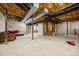 Spacious unfinished basement features exposed ductwork, sealed concrete flooring, and some furnishings at 3203 Rugby Rd, Durham, NC 27707