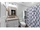 Well-lit bathroom featuring granite countertops and a shower with a patterned curtain at 3203 Rugby Rd, Durham, NC 27707
