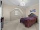 Bedroom with neutral walls, small window, decorative chandelier and chandelier, and plush purple bedding at 3203 Rugby Rd, Durham, NC 27707