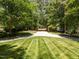 Well-manicured lawn with a circular driveway entrance lined with mature trees at 3203 Rugby Rd, Durham, NC 27707