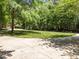 Long, curved driveway leading to the property, surrounded by a manicured lawn and mature trees at 3203 Rugby Rd, Durham, NC 27707