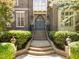 Beautiful brick steps lead to the home's arched entry, framed by manicured bushes and lighting at 3203 Rugby Rd, Durham, NC 27707