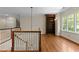 Second floor landing featuring wood floors, staircase, and custom built-in bookcase at 3203 Rugby Rd, Durham, NC 27707