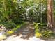 Charming stone pathway lined with lush greenery and a tiered fountain, enhancing the landscape at 3203 Rugby Rd, Durham, NC 27707