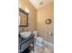 Charming half bathroom with a vessel sink, vanity, tile flooring, and decorative mirror at 325 Hogans Valley Way, Cary, NC 27513