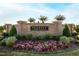 Flowers Plantation community entrance with brick signage, lush foliage, and colorful flowers at 33 White Ash Dr, Clayton, NC 27527