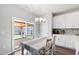 Bright dining area with white table and chairs, sliding glass doors to the backyard, and kitchen access at 33 White Ash Dr, Clayton, NC 27527