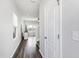 Hallway with hardwood floors leading to a living area filled with natural light and a ceiling fan at 33 White Ash Dr, Clayton, NC 27527