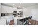 Bright kitchen featuring white cabinets, stainless steel appliances, an island with bar stools, and tiled backsplash at 33 White Ash Dr, Clayton, NC 27527