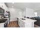 Kitchen with white cabinets, stainless steel appliances, island with sink and seating, and access to living room at 33 White Ash Dr, Clayton, NC 27527