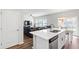 Open kitchen with island, stainless steel appliances, view of living area, and adjacent dining space with sliding doors at 33 White Ash Dr, Clayton, NC 27527
