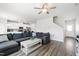 Comfortable living room featuring a large gray couch, ceiling fan, and open access to the modern kitchen at 33 White Ash Dr, Clayton, NC 27527